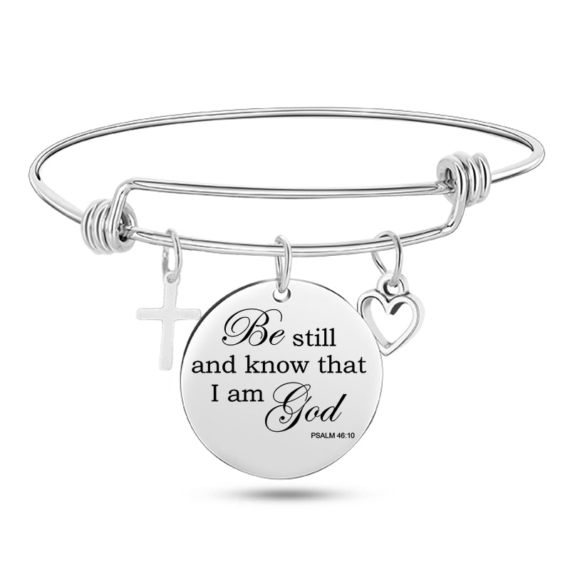 Silver bracelet with a round charm featuring 'Be still and know that I am God' text on a white background