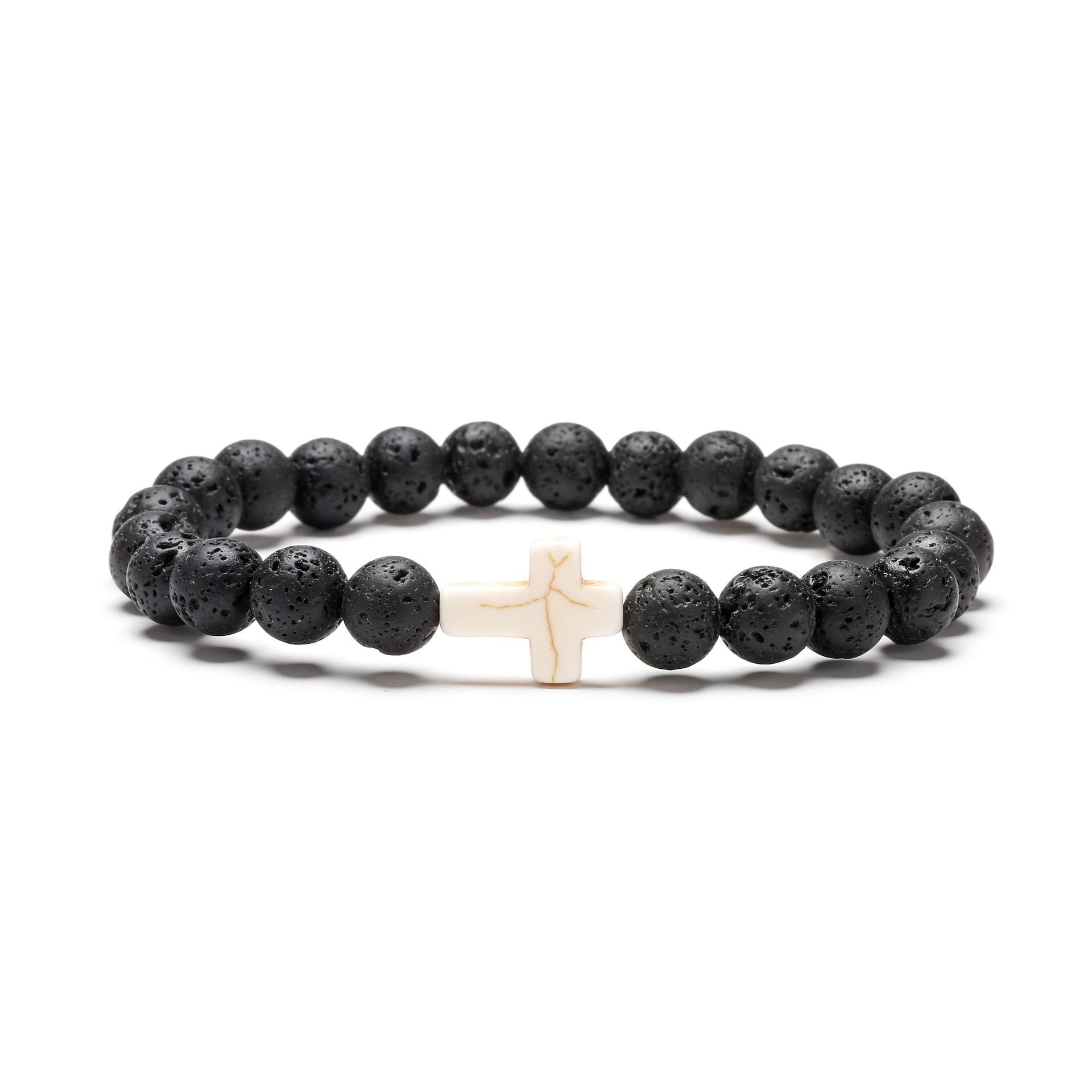 Black beaded bracelet with a white cross charm on a white background