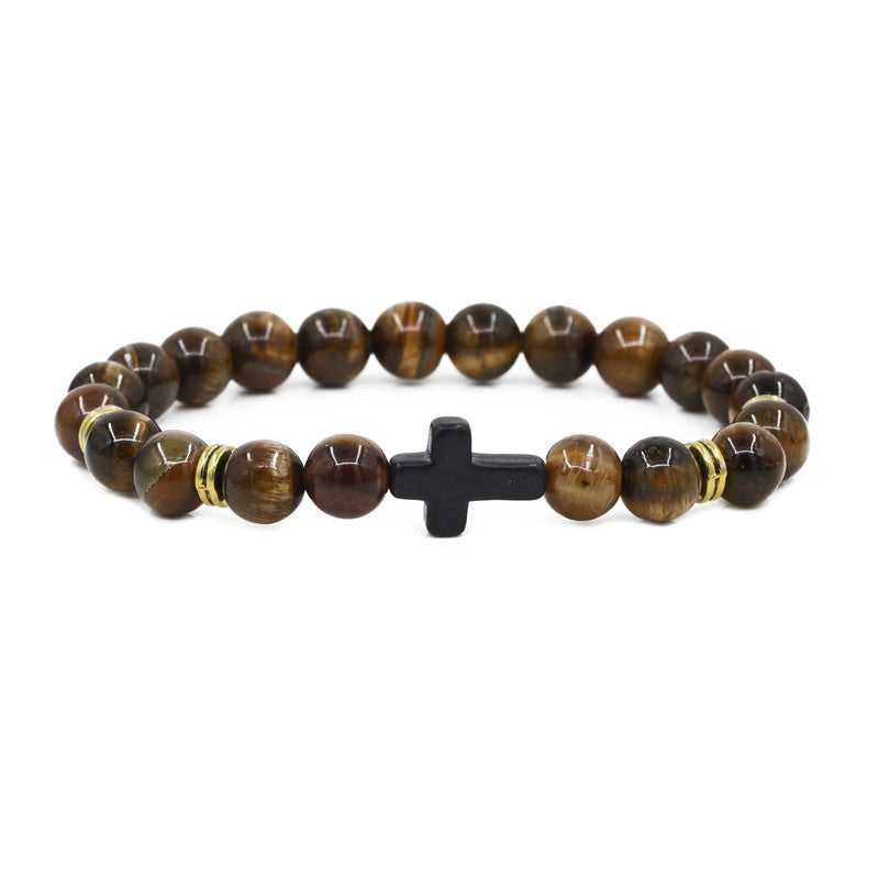 Beaded bracelet with a black cross charm on a white background
