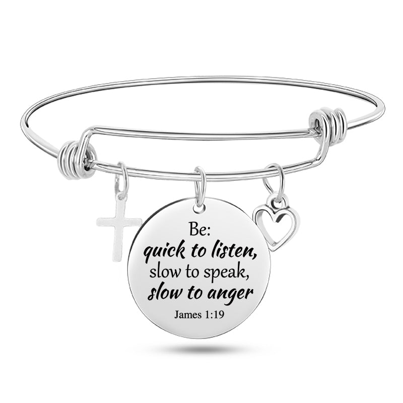 Silver bracelet with a circular charm featuring a quote and religious symbols on a white background