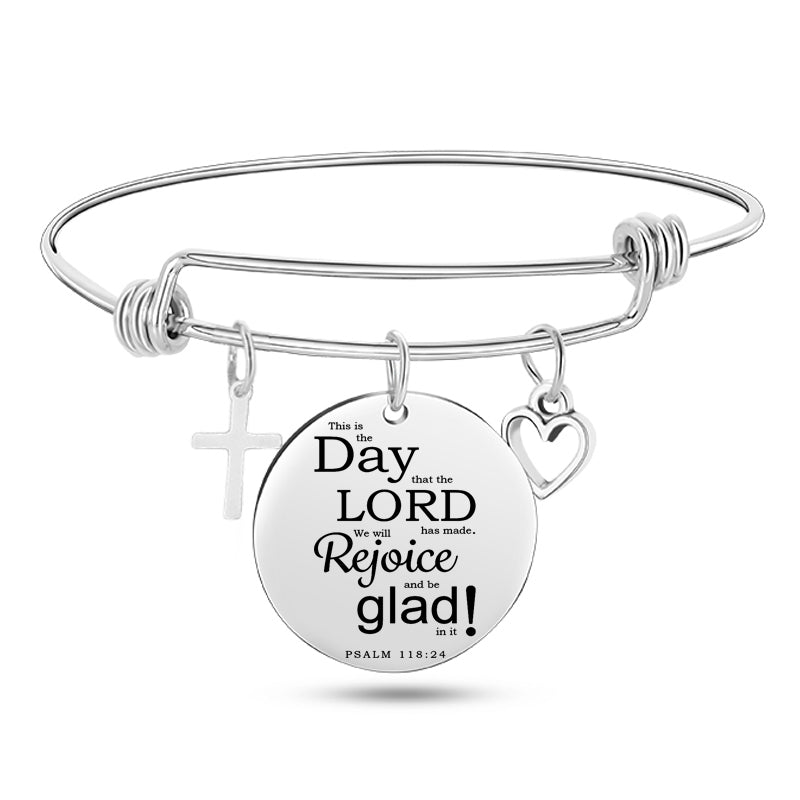 Silver bracelet with a round engraved disc on a white background