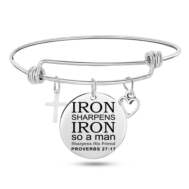 Silver bracelet with a round charm featuring text and religious symbols on a white background