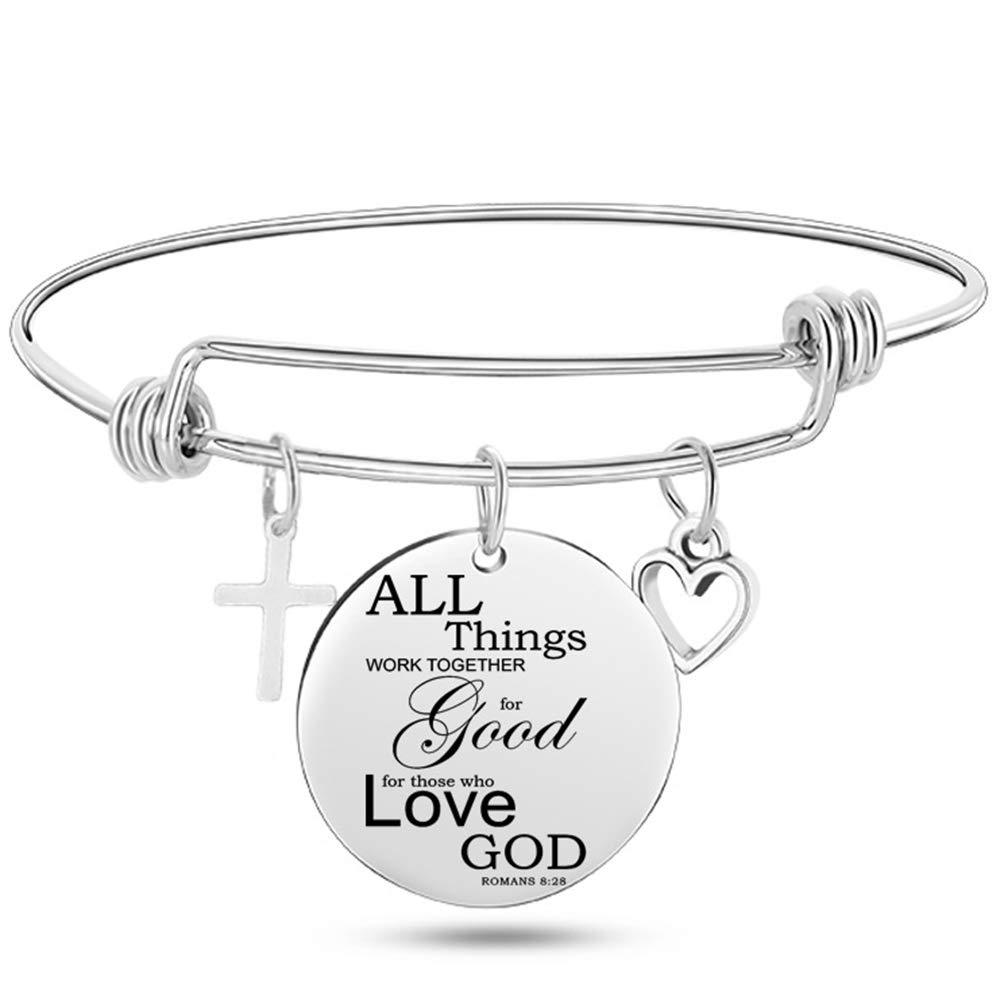 Silver bracelet with a round engraved charm and heart and cross charms on a white background