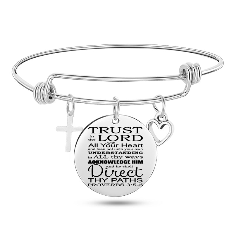 Silver bracelet with a circular charm featuring text and religious symbols on a white background